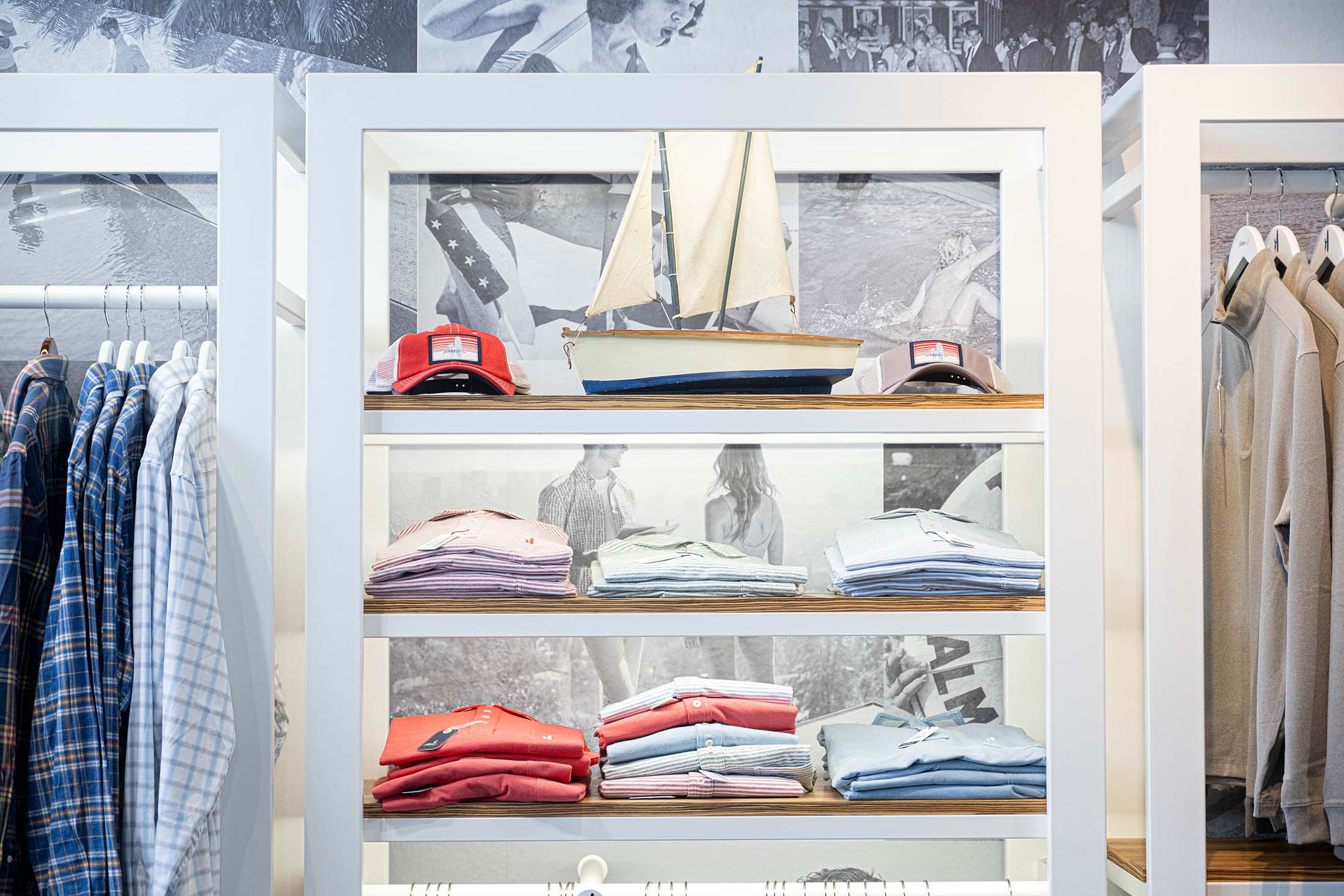An in-store display with a model boat, hats, and shirts